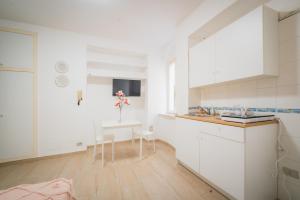 代森扎诺-德尔加达Suite "Castello" del Garda - APT per coppie Garda的厨房配有白色橱柜和小桌子