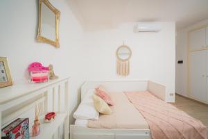 代森扎诺-德尔加达Suite "Castello" del Garda - APT per coppie Garda的白色卧室配有带粉红色枕头的床
