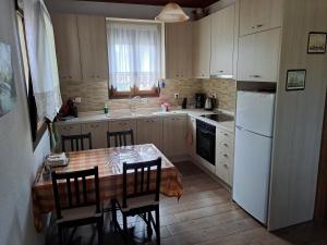 奥马斯帕纳吉亚斯Konaki Guesthouse的厨房配有桌椅和白色冰箱。