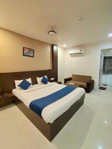 艾哈迈达巴德Hotel Palav Palace的一间卧室配有一张带蓝色枕头的大床