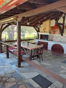 奥马斯帕纳吉亚斯Konaki Guesthouse的一个带木桌的庭院和一间厨房
