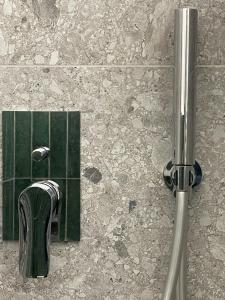 米兰MILA by The Blue Twins apartments Milano的浴室设有绿色瓷砖和淋浴。