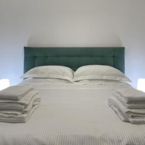 米兰MILA by The Blue Twins apartments Milano的一张带白色枕头和绿色床头板的床