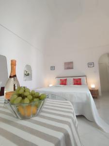 阿纳卡普里L'Archetto romantic suite in the center of Anacapri的一间卧室配有一张床,桌上放着一碗水果