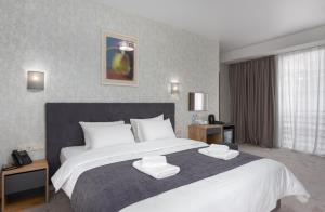 第比利斯Brooch Boutique Hotel的卧室配有带白色枕头的大床