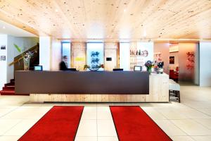 慕尼黑德瑞洛温酒店的大堂设有前台和红色地毯