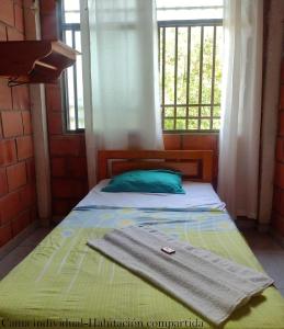 PepinoHostal Ariantiy的一张带毛巾的床,带窗户