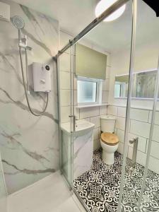 普里茅斯Large Home Sleeps 6 Central Location Free Parking的一间带卫生间和玻璃淋浴间的浴室