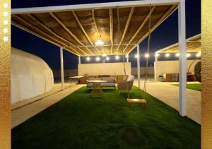 拉斯阿尔卡麦Desert Breeze Cocoon的草坪上带桌椅的帐篷