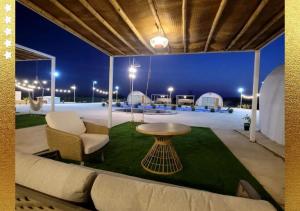 拉斯阿尔卡麦Desert Breeze Cocoon的天井配有沙发、桌子和灯