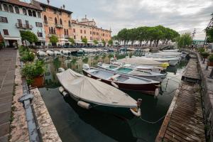 代森扎诺-德尔加达Suite "Castello" del Garda - APT per coppie Garda的一群船停靠在运河上,有建筑物