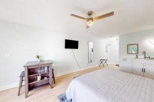 马可岛Capri 103的白色卧室配有床和平面电视
