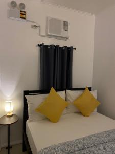 SorsogonDreamink farm og Myl`s place的一间卧室配有一张带两个黄色枕头的床