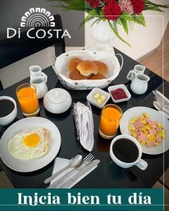 皮乌拉Di Costa Hotel的餐桌上摆放着早餐食品和橙汁