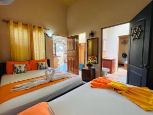 别霍港Villas Allen Puerto Viejo的一间卧室配有两张橙色和黄色的床