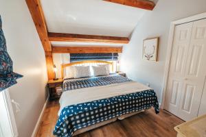 贝塞尔Newly Renovated, Spacious Condo, 3 min to the ski lifts!的一间带一张床的卧室,位于带木制天花板的房间内
