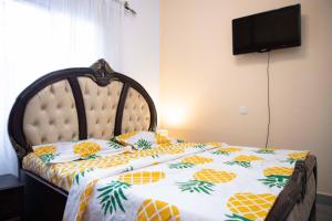 雅温得Hypo Guest Lounge的一间卧室配有一张带 ⁇ 萝床罩的床。