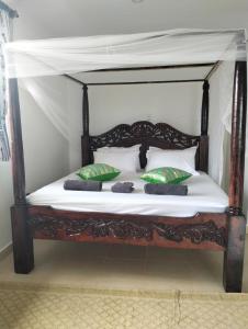 GaluDiani Hideaway Beach Villa的一张带枕头的木床