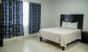 马德罗城Hotel Tampico Express的一间卧室配有床和带窗帘的窗户