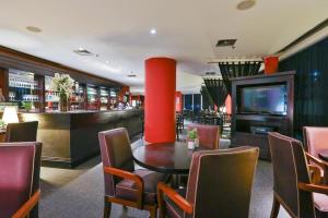 圣保罗Suite executiva reformada dentro do hotel Radisson的一间带桌椅的餐厅和酒吧