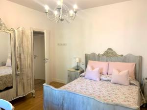 佩波利堡Appartamento Simona的一间卧室配有一张带粉红色枕头和吊灯的床。