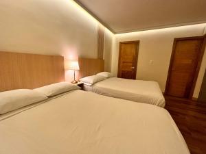 圣多明各Hotel La Colonia的酒店客房,设有两张床和一盏灯