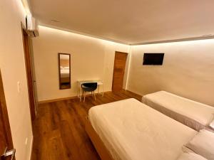 圣多明各Hotel La Colonia的酒店客房设有两张床和一张桌子。