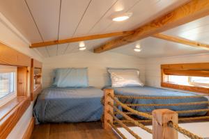Apple ValleyAloha Tiny Home的一个小房子的小房间里设有两张床
