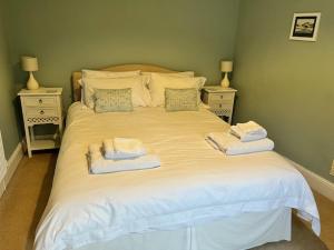 波马利斯Amelie Cottage的一张白色的床,上面有两条毛巾