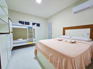 纳塔尔MANERO POUSADA e HOSTEL的一间卧室配有一张床和一张双层床。