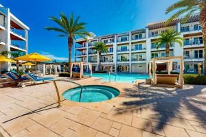 罗斯玛丽海滩The Pointe 3-315的一个带椅子和棕榈树的游泳池的度假酒店
