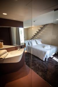 瓦讷Le Roscanvec的一间卧室配有一张床,浴室设有水槽