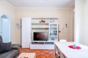 罗扎诺Moderno appartamento a due passi dai Navigli的一间客厅,在白色娱乐中心配有电视