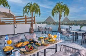 开罗Peace Inn West Pyramids Cairo的棕榈树庭院里的早餐桌