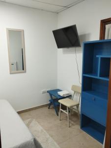 胡宁Albajunin的一间卧室配有蓝色梳妆台和一张带电视的书桌。