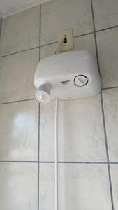 约恩维利Quarto privativo WC compartilhado的白色的吹风机,坐在浴室的瓷砖地板上