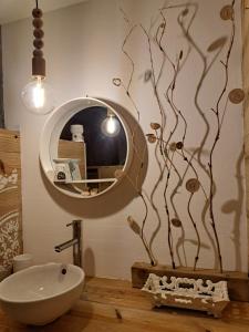 大博格P'tites chambres dans la campagne de Marie Galante的一间带圆形镜子和水槽的浴室