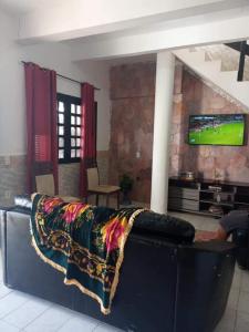 考卡亚Pousada e Hostel Lua de Tomate的客厅的沙发,墙上配有电视
