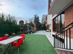 第比利斯villa with beautiful views的绿色草坪上带桌椅的庭院
