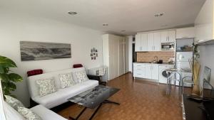 塔科龙特PURA VIDA的一间带白色沙发的客厅和一间厨房