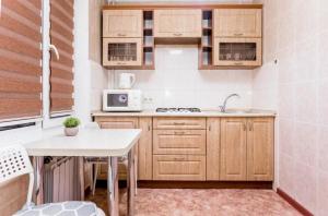 阿拉木图Яркая Квартира на Арбате的一个带木制橱柜和桌子的小厨房