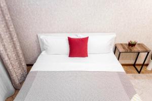 阿拉木图Яркая Квартира на Арбате的一张白色的床,上面有红色枕头