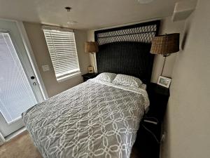滨海城Marina Dunes Park Model的一间卧室配有一张带白色棉被的床和两个窗户