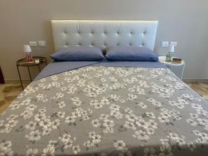 佩罗MyCosmoStudio的床上有一条布满白色花的毯子