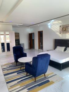 达喀尔BI HOTEL 2的一间卧室配有一张床、两把椅子和一张桌子