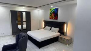 达喀尔BI HOTEL 2的一间卧室配有一张床和一把椅子