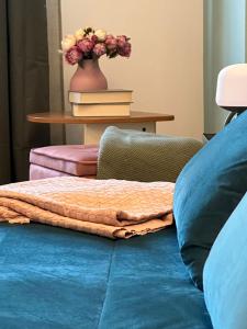 佩罗MyCosmoStudio的一张带枕头的床和一张花瓶桌子