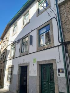 科维良Covilhã Hostel的街道上带绿门的白色建筑