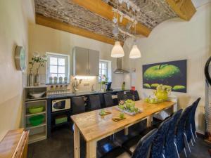 艾斯登Located 10km from Maastricht towards the Belgium border的厨房以及带木桌和椅子的用餐室。