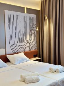 萨拉热窝The Place 87的两张位于酒店客房的床,配有毛巾